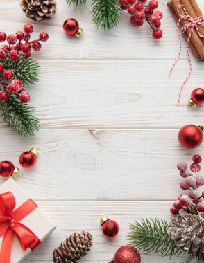 Beyaz ahşap arka planda bir çerçeve oluşturan hediyeli Noel süsü. Noel teması. Düz yat, boşluğu kopyala
