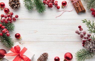 Beyaz ahşap arka planda bir çerçeve oluşturan hediyeli Noel süsü. Noel teması. Düz yat, boşluğu kopyala