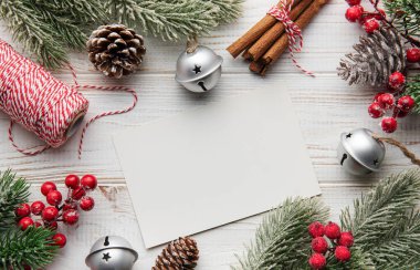 Noel arkaplanı köknar ağacı, kartpostal ve beyaz ahşap arka planda dekor. Kopyalama alanı olan üst görünüm