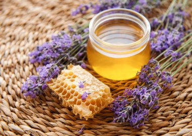 Bir bardak bal, bal peteği ve lavanta çiçeği.