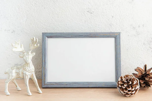 White blank wooden frame mockup with Christmas decorations  on the wooden table.  Frame for quotes. Christmas postcard
