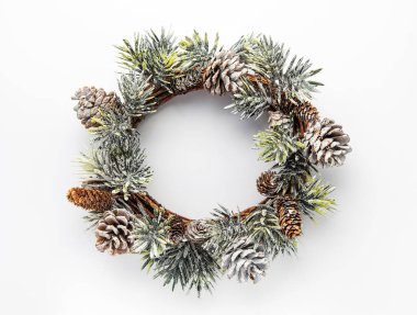 Dekoratif Noel çelengi. Köknar ağacından çelenk ve beyaz arka planda koni. Noel süslemeleri