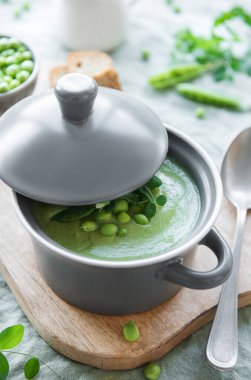 Fresh green pea soup bowl on gray concrete background