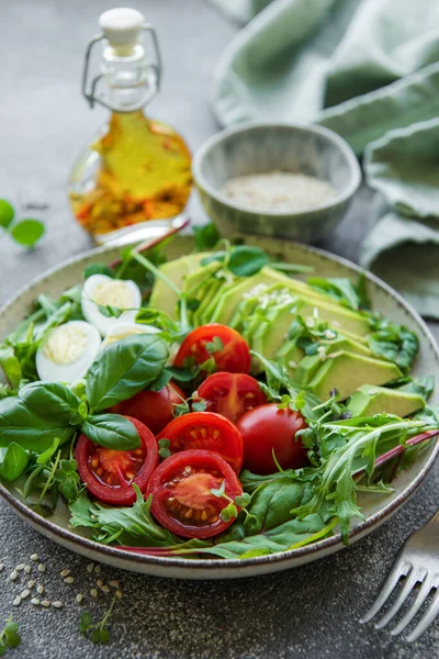 Stock image Fresh summer salad with arugula,  red cherry tomatoes, basil, eggs and avocado. Vegan food. Healthy salad