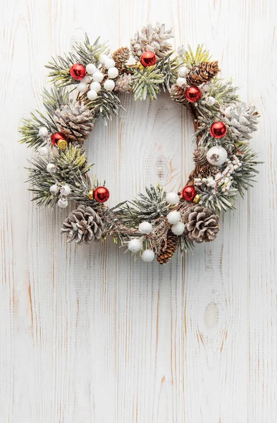 Decorative festive Christmas wreath. Wreath made of fir tree and cones on a old wooden background. Christmas decorations