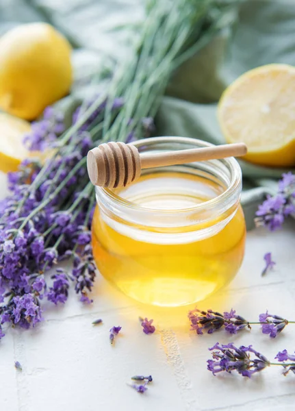 stock image Glass of honey, honeycomb and lavender flowers