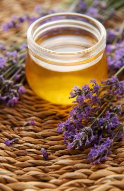 Glass of honey, honeycomb and lavender flowers