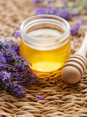 Glass of honey, honeycomb and lavender flowers