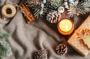 Sıcak süveteri, hediye kutusu, mumu ve süslemeleri olan Noel ve kış örtüsü..