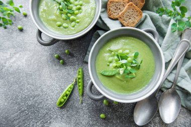 Fresh green pea soup bowl on gray concrete background