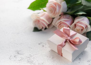 Bir buket pembe gül ve çimento kaplı hediye kutusu. Sevgililer Günü