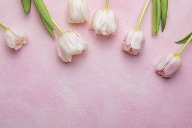 Pembe arka planda bir buket pembe lale. Anneler günü, sevgililer günü, doğum günü kutlaması konsepti. Tebrik kartı. Metin için boşluk kopyala, üst görünüm