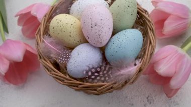 A woman's hand takes a colored Easter egg on the table. The concept of preparing for the Easter holiday
