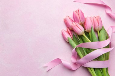 Pembe arka planda bir buket pembe lale. Anneler günü, sevgililer günü, doğum günü kutlaması konsepti. Tebrik kartı. Metin için boşluk kopyala, üst görünüm