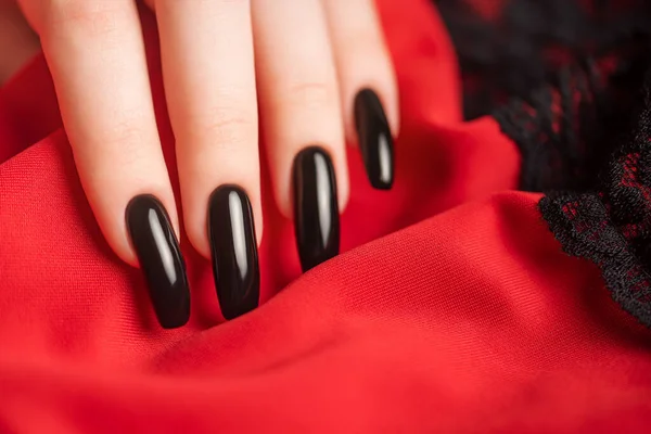 Ręka Młodej Dziewczyny Czarnym Manicure Paznokciach Czerwonym Tle Czarną Koronką — Zdjęcie stockowe