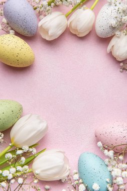 Mutlu Paskalya bayramı tebrik kartları. Beyaz lale buketi ve pembe arka planda Paskalya yumurtası. Metin için boşluk