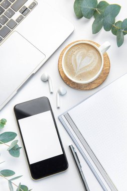 White Office desk table with laptop, supplies and coffee cup.  Space for text