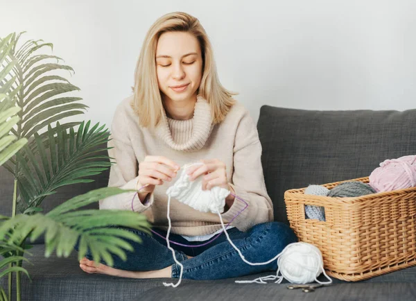 stock image Young woman knitting warm scarf at home