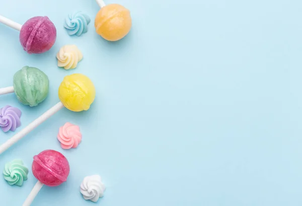 stock image Colorful sweet lollipops and candies over blue background.  Flat lay, top view