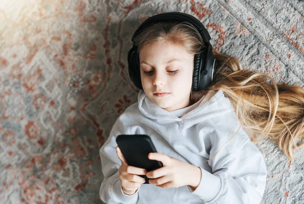 Petite Fille Souriante Écoutant Musique Couchée Sur Sol — Photo