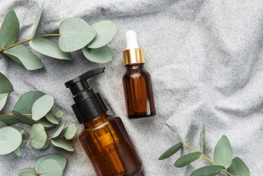 Tekstil kumaş arka planında okaliptüs bulunan masaj ve spa ürünleri
