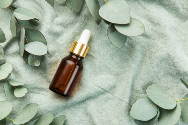 Tekstil kumaş arka planında okaliptüs bulunan masaj ve spa ürünleri