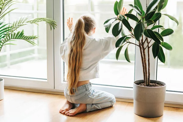 stock image Lonely sad little girl sitting by the window.