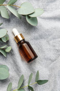 Tekstil kumaş arka planında okaliptüs bulunan masaj ve spa ürünleri