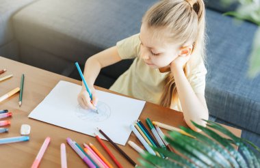 Evde renkli kalemlerle resim çizen kız çocuğu. Ekoloji konsepti, dünyayı boyamak.. 