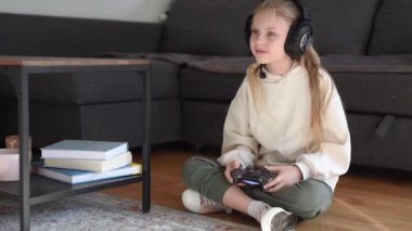 Playstation 'ı olan küçük bir kız. Evde bir playstation ile online oyun oynayan küçük bir kızın görüntüsü.