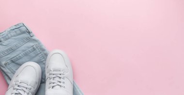 Çocuk kotları ve beyaz spor ayakkabıları, gündelik tarz. Modern çocuk aksesuarları. Üst Manzara Düz Yat. Pembe arkaplan