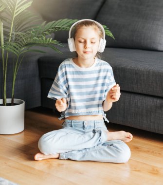 Evde kulaklıkla müzik dinleyen tatlı küçük kız..