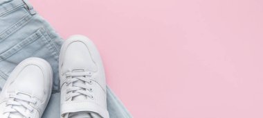 Çocuk kotları ve beyaz spor ayakkabıları, gündelik tarz. Modern çocuk aksesuarları. Üst Manzara Düz Yat. Pembe arkaplan
