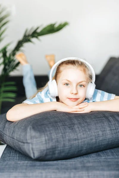 Cute Little Girl Listening Music Headphones While Lying Sofa Home — Stock Photo, Image