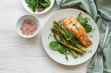 Pişmiş lezzetli somon, yeşil kuşkonmaz ve sebze tabağı. 