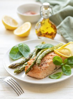 Pişmiş lezzetli somon, yeşil kuşkonmaz ve sebze tabağı. 