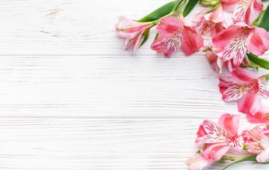 Tebrik metni çerçevesi, tahta bir arka planda Alstroemeria çiçekleri. Doğal renklerde tebrik kartı. Alstromeria içeren metinler için arka plan. Düz yatış, üst görünüm.