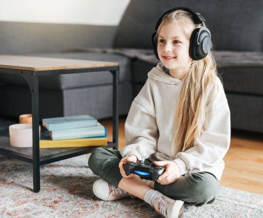 Küçük bir kız elinde oyun kontrolörü video oyunları oynuyor