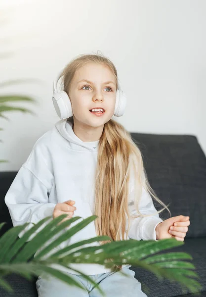 可爱的小女孩在家里用耳机听音乐 — 图库照片