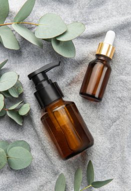 Tekstil kumaş arka planında okaliptüs bulunan masaj ve spa ürünleri