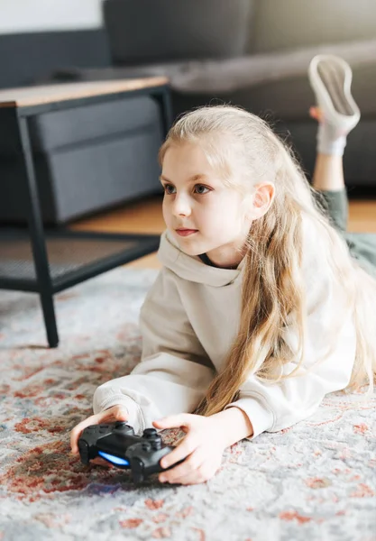 女の子は自宅でゲーム機で遊んでいます — ストック写真