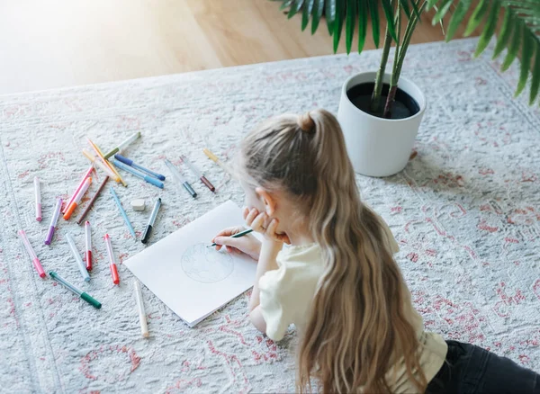 stock image Child girl drawing with colorful pencils at home. Ecology concept, painting earth. 