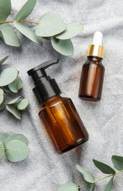 Tekstil kumaş arka planında okaliptüs bulunan masaj ve spa ürünleri