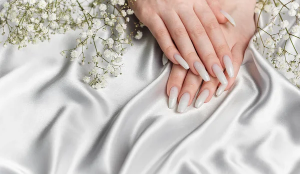 美容美发漂亮修整过的女人指甲带有漂亮的白色指甲油和吉普赛花的女钉艺术 — 图库照片