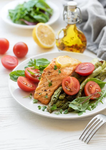 stock image Baked Delicious salmon, green asparagus with vegetables on plate 