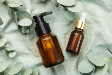 Tekstil kumaş arka planında okaliptüs bulunan masaj ve spa ürünleri
