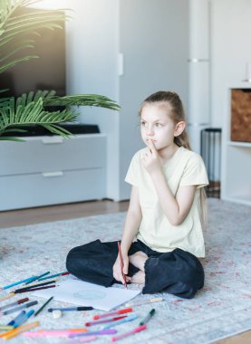 Evde renkli kalemlerle resim çizen kız çocuğu. Ekoloji konsepti, dünyayı boyamak.. 