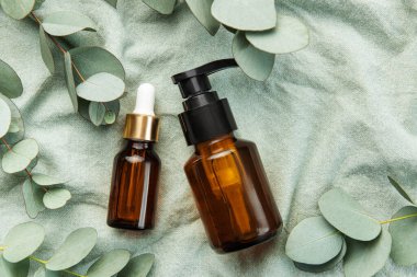 Tekstil kumaş arka planında okaliptüs bulunan masaj ve spa ürünleri