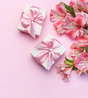 Tebrik metni çerçevesi, Alstroemeria çiçekleri ve pembe arka planda hediye kutuları. Doğal renklerde tebrik kartı. Alstromeria içeren metinler için arka plan. Düz yatış, üst görünüm.