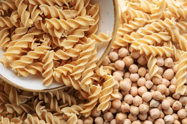 Chickpea bean fusilli pasta. Bowl with raw pasta and chickpea bean. Gluten free pasta.